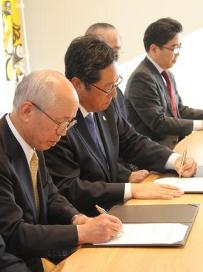 協定書に署名する中村市長と後藤社長