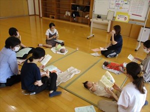 説明を聞くお母さんと赤ちゃんの写真 説明を聞くお母さんと赤ちゃんの写真